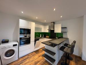 a kitchen with a washing machine and a washer and dryer at FeWo Landidyll in Dürrnberg