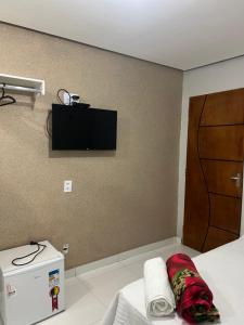 a room with a bed with a television on the wall at Hotel Santa Rita in Amarante do Maranhão