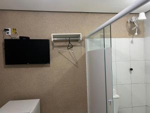 a bathroom with a flat screen tv on the wall at Hotel Santa Rita in Amarante do Maranhão