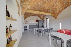 a kitchen and dining room with white tables and chairs at La Porta delle Meraviglie in Saluzzo