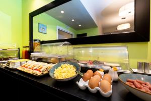 a buffet with eggs and other food on a counter at Chic&Town Luxury Rooms Piazza del Popolo 1 in Rome