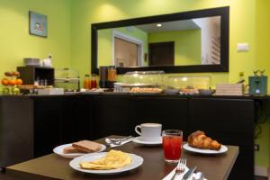 a table with two plates of food and a mirror at Chic&Town Luxury Rooms Piazza del Popolo 1 in Rome +36 photos