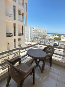 a balcony with a table and two chairs and a view of the ocean at Downtown Keys in Hurghada