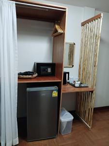 a small refrigerator in a room with a shelf at Beachfront Hotel Cha Am in Cha Am