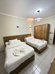 a bedroom with two beds with towels on them at Downtown Keys in Hurghada