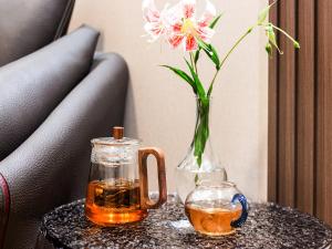 a vase with a flower and a drink on a table at Kunming Annie Apartment 3201-100 meters From Metro Line 2 exit of Chuanxingulou in Kunming