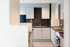 a kitchen with white cabinets and a sink at Stay at St Marks in Lincoln