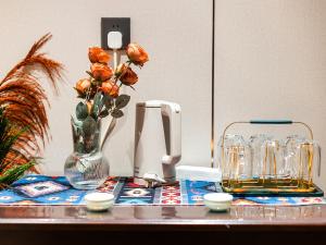 a table with a vase with flowers in it at Kunming Annie Apartment 3201-100 meters From Metro Line 2 exit of Chuanxingulou in Kunming