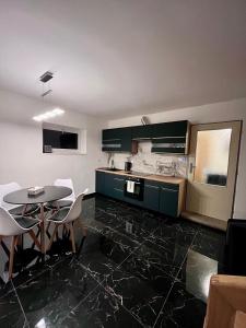 a kitchen with green cabinets and a table and chairs at ZANIK Cozy Haven in Prague