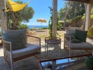 a patio with chairs and a table and an umbrella at Fetovaia Magic Holiday Villa in Fetovaia