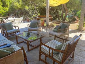 a patio with chairs and tables and an umbrella at Fetovaia Magic Holiday Villa in Fetovaia