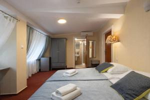 two beds in a hotel room with towels on them at Royal Rooms Self Check-in in Poznań +70 photos