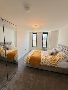 a bedroom with two beds and a mirror at Grace House in St. Albans