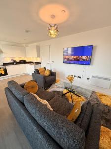 a living room with a couch and a tv at Grace House in St. Albans