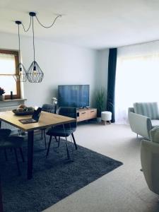 a living room with a table and a television at Wanderlust Chiemgau in Bad Endorf