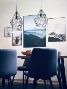a dining room table with two chairs and pictures on the wall at Wanderlust Chiemgau in Bad Endorf