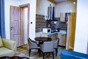 a kitchen with a table and chairs in a room at Fobbs Apartment and Suites in Asaba
