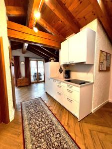 a kitchen with white appliances and a wooden ceiling at Ferienwohnung Mahlert im Haus Sonnenschein in Reit im Winkl +5 photos