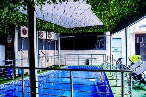 a balcony with a swimming pool with a table and chairs at Fobbs Apartment and Suites in Asaba
