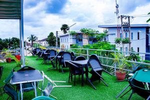 a row of tables and chairs on a balcony at Fobbs Apartment and Suites in Asaba