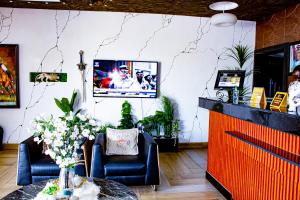 a room with two chairs and a table with flowers at Fobbs Apartment and Suites in Asaba