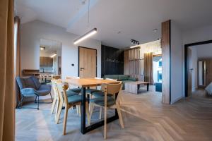 a dining room and living room with a table and chairs at Apartamenty Beski in Szczyrk