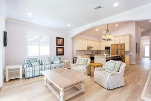 a living room with a table and chairs and a kitchen at Imola Vacation Rental - Remodeled Pool Home Minutes from Vanderbilt Beach! Family-Friendly Retreat with 4 BR 4 BA and Private Screened Pool! in Naples