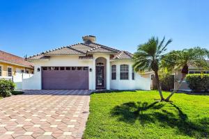 a house with a palm tree in front of it at Imola Vacation Rental - Remodeled Pool Home Minutes from Vanderbilt Beach! Family-Friendly Retreat with 4 BR 4 BA and Private Screened Pool! in Naples