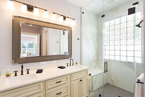 a bathroom with a sink and a shower and a mirror at Imola Vacation Rental - Remodeled Pool Home Minutes from Vanderbilt Beach! Family-Friendly Retreat with 4 BR 4 BA and Private Screened Pool! in Naples