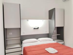 a bedroom with a bed with a red blanket and white cabinets at Le Zagare Case Vacanza in Cropani