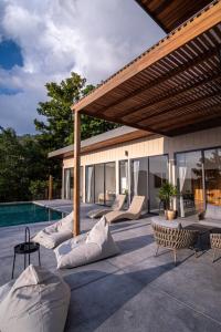 a patio with lounge chairs and a swimming pool at InnSpire Villa - Breathtaking Sunset View in Hinkong