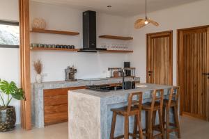 a kitchen with a counter and a island with stools at InnSpire Villa - Breathtaking Sunset View in Hinkong