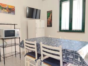 a dining room table with two chairs and a tv at Le Zagare Case Vacanza in Cropani