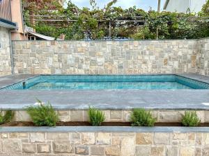 a swimming pool with a stone retaining wall and a stone retaining wall at Apartment Sunset - Private Pool & Sea View in Bar