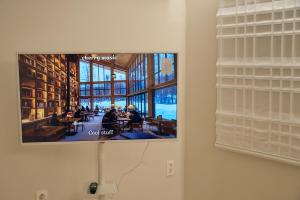 a flat screen tv hanging on a wall in a library at Stay Seongsu Villa in Seoul