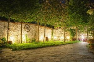 a stone wall with trees and a path at night at Hagiati Guesthouse - Edessa Cozy Mountain Retreat in Edessa +31 photos