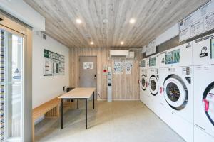 a laundry room with a table and washing machines at Seed INN Haneda Terrace 201 in Tokyo