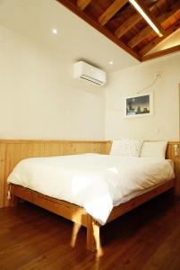 a bedroom with a large bed with white sheets at Dorandoran Guesthouse in Gyeongju