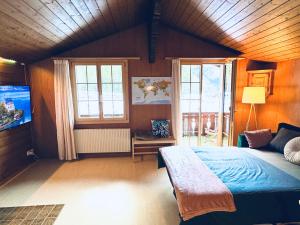 a bedroom with a bed and a flat screen tv at Bergtraum Suite in Kandersteg