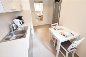 a kitchen with a sink and a table with chairs at Apartment Katamaran in Krakow