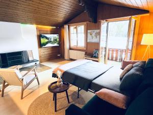 a bedroom with a large bed and a couch at Bergtraum Suite in Kandersteg