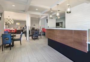 a restaurant with a bar with chairs and tables at Hotel 1550 - SFO Airport West in San Bruno