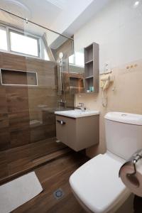 a bathroom with a toilet and a shower and a sink at Airport West Hotel in Accra +47 photos