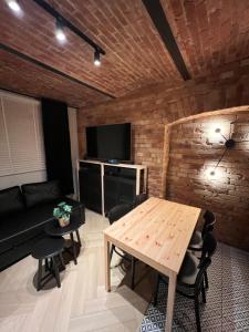 a living room with a wooden table and a television at Apartament M6 in Leśna +5 photos