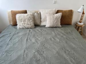 a bed with a gray blanket and pillows at Guesthouse in Neuhäusel