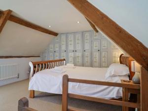 a bedroom with a large bed in a attic at Rope Cottage in Bridport