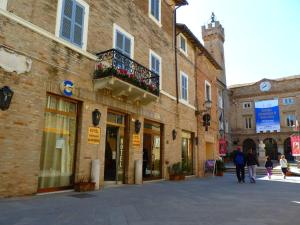 un gruppo di persone che camminano per una strada accanto agli edifici di Hotel Giardinetto a Loreto