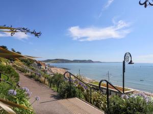 a walkway leading down to a beach with a clock at Rope Cottage in Bridport