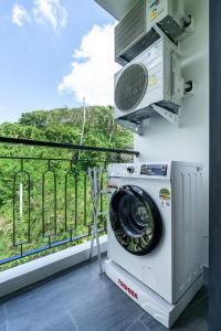 a washing machine in a room with a balcony at Palmetto Park Residence in Karon Beach
