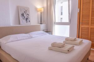 a bedroom with a white bed with towels on it at Casa LoIa Altea By DelucaCo in Altea +61 photos